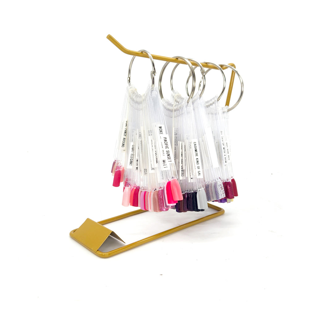 Set of colorful lip gloss tubes on a gold stand against a white background