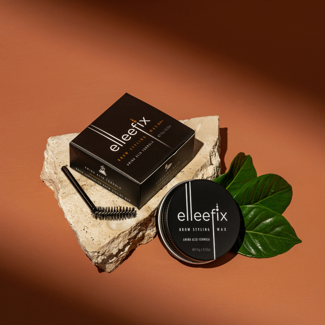 elleefix brow styling wax packaging with applicator and leaves on a stone surface